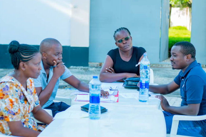 Stiftungsvertreter sitzen um einen Tisch im Freien vor dem Gebäude der Stiftung in Dar es Salaam