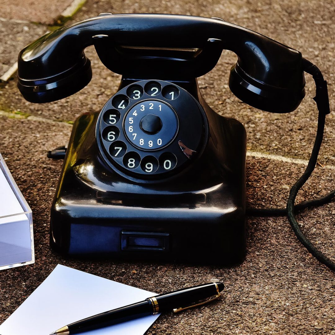 Ein altes, schwarzes Telefon mit Wählscheibe